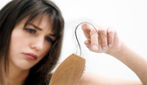 lady with hair thinning and a comb